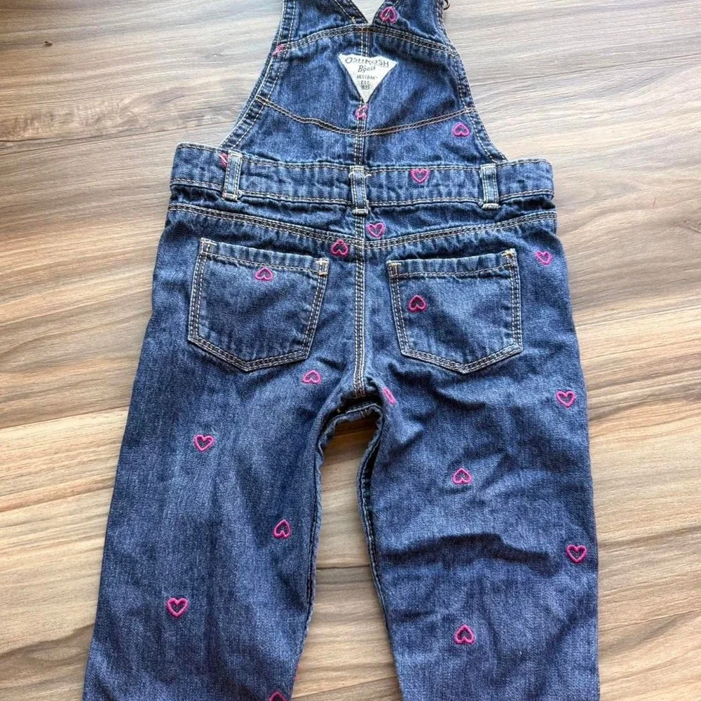 OshKosh B'gosh blue denim overalls with pink heart embroidery